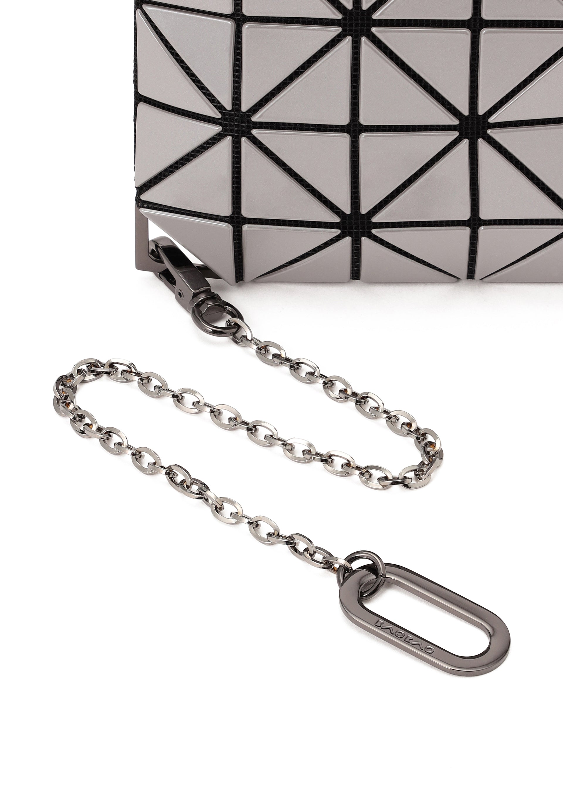 Zoomed view Close-up of the FLIPPER bag by BAO BAO ISSEY MIYAKE, featuring a geometric pattern, silver chain strap, and metal clasp—ideal for carrying essentials like a commuter pass case or business card holder on a white surface.