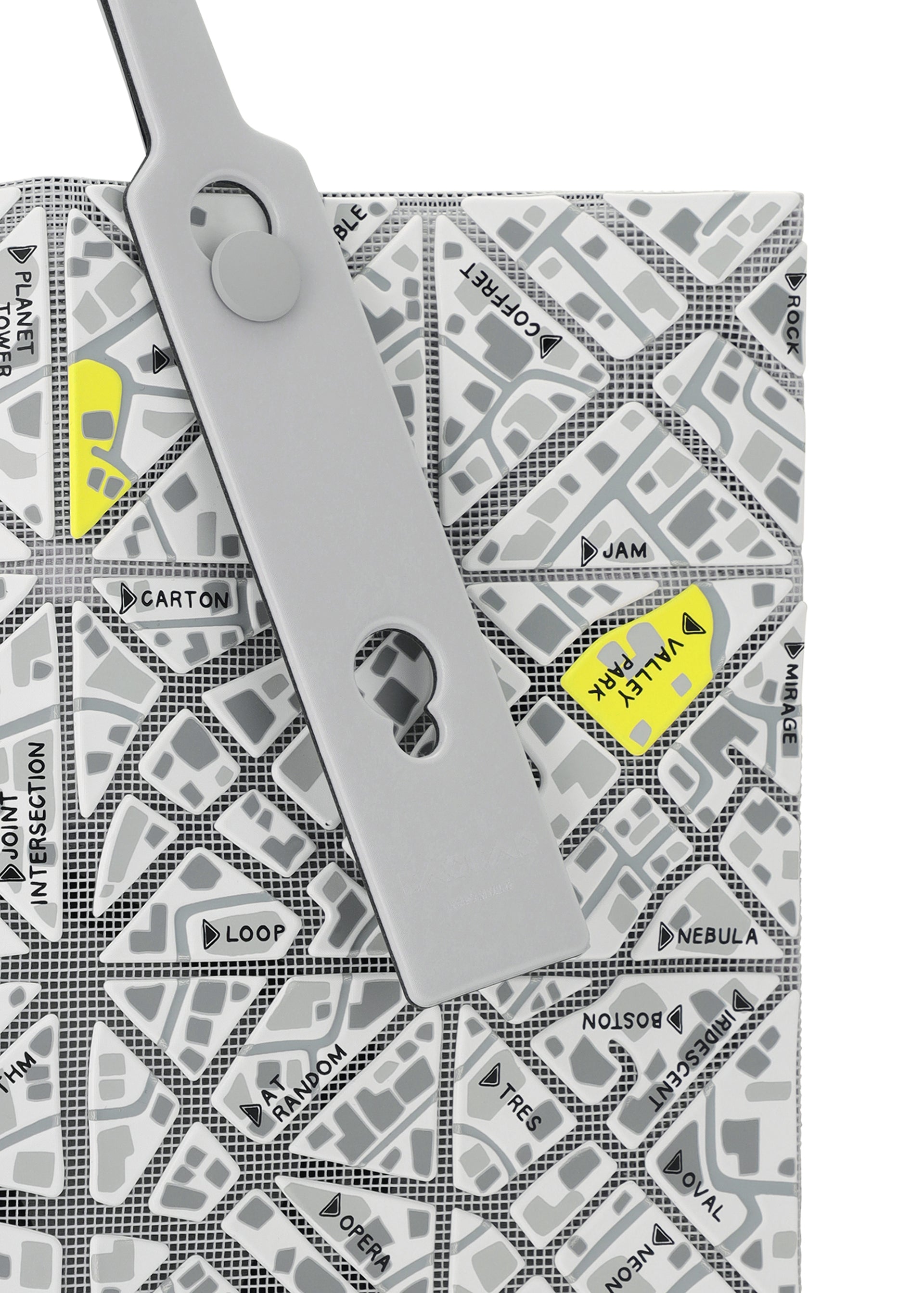 Zoomed view A gray binder clip fastens a BAO BAO ISSEY MIYAKE MAP folder featuring a geometric street map design with names like VAULT, JAM, and NEBULA highlighted in yellow.