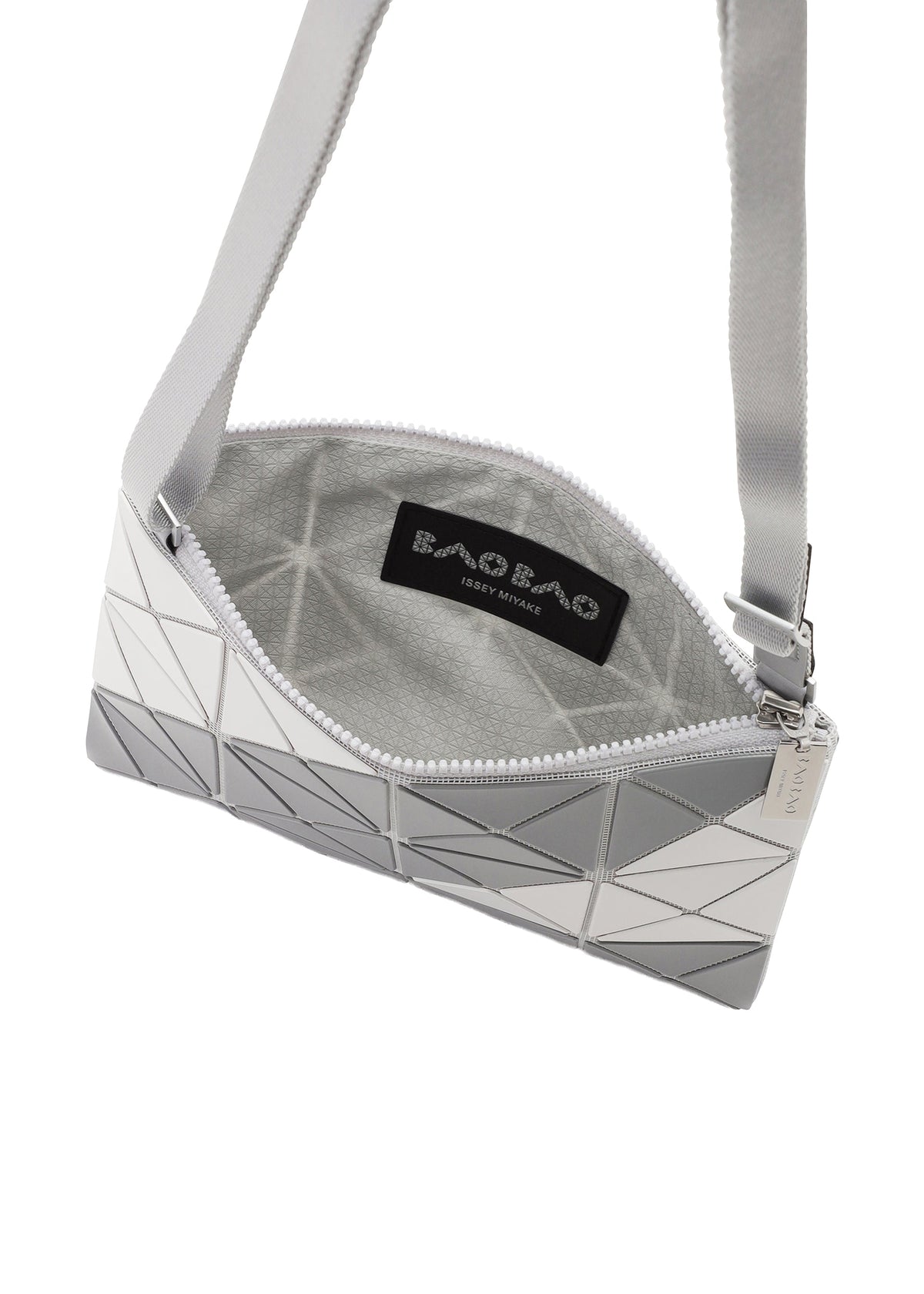 The SIGN crossbody by BAO BAO ISSEY MIYAKE features a geometric white and gray exterior with a road sign-inspired triangular tile pattern, zippered opening, gray interior, and an inner “BAO BAO ISSEY MIYAKE” label. view 5 of 6