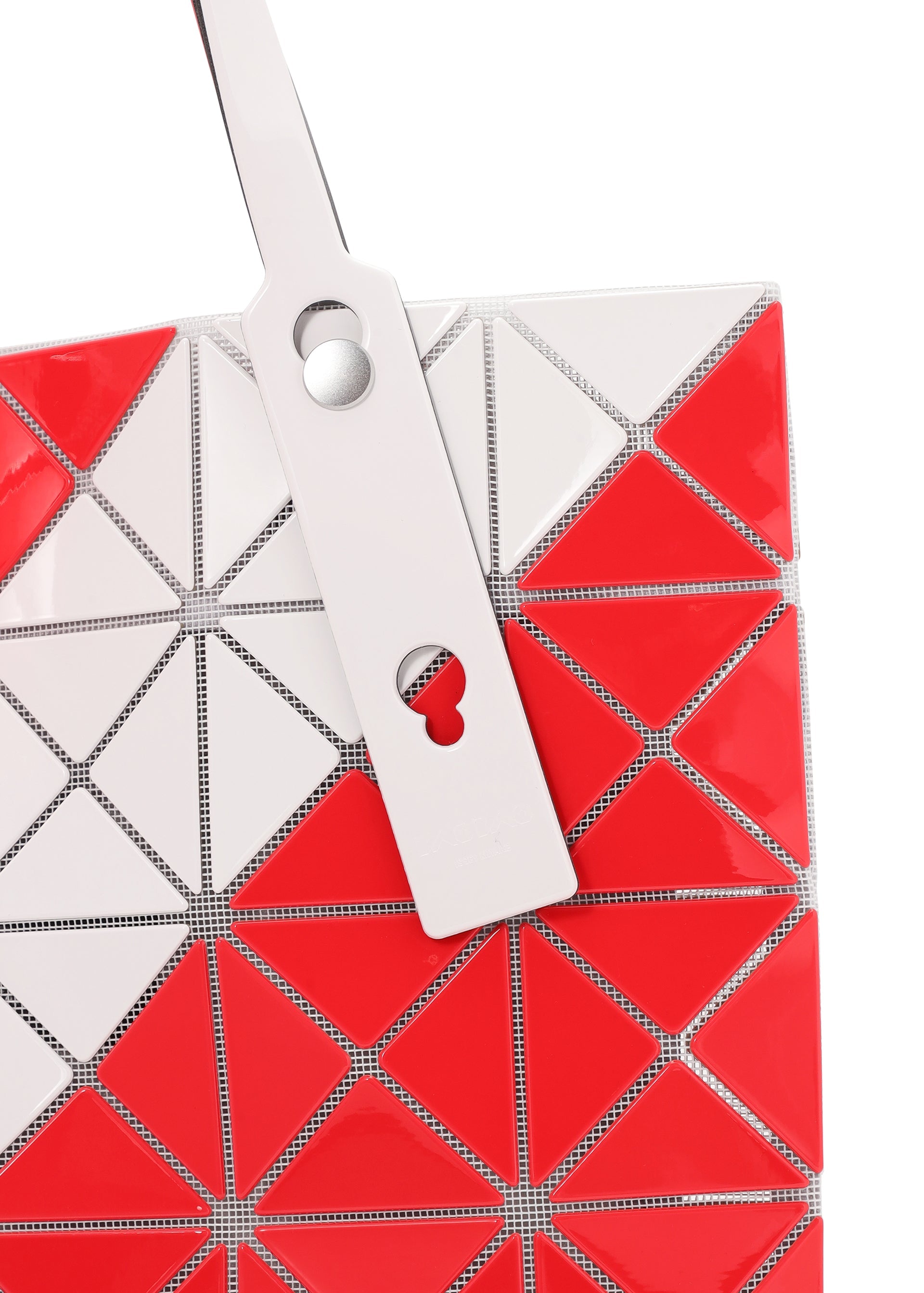 Zoomed view A close-up of the SIGN tote bag by BAO BAO ISSEY MIYAKE, featuring a red and white geometric triangular pattern and a tag with circular and keyhole cutouts—ideal for carrying A4 documents or a 13-inch laptop.