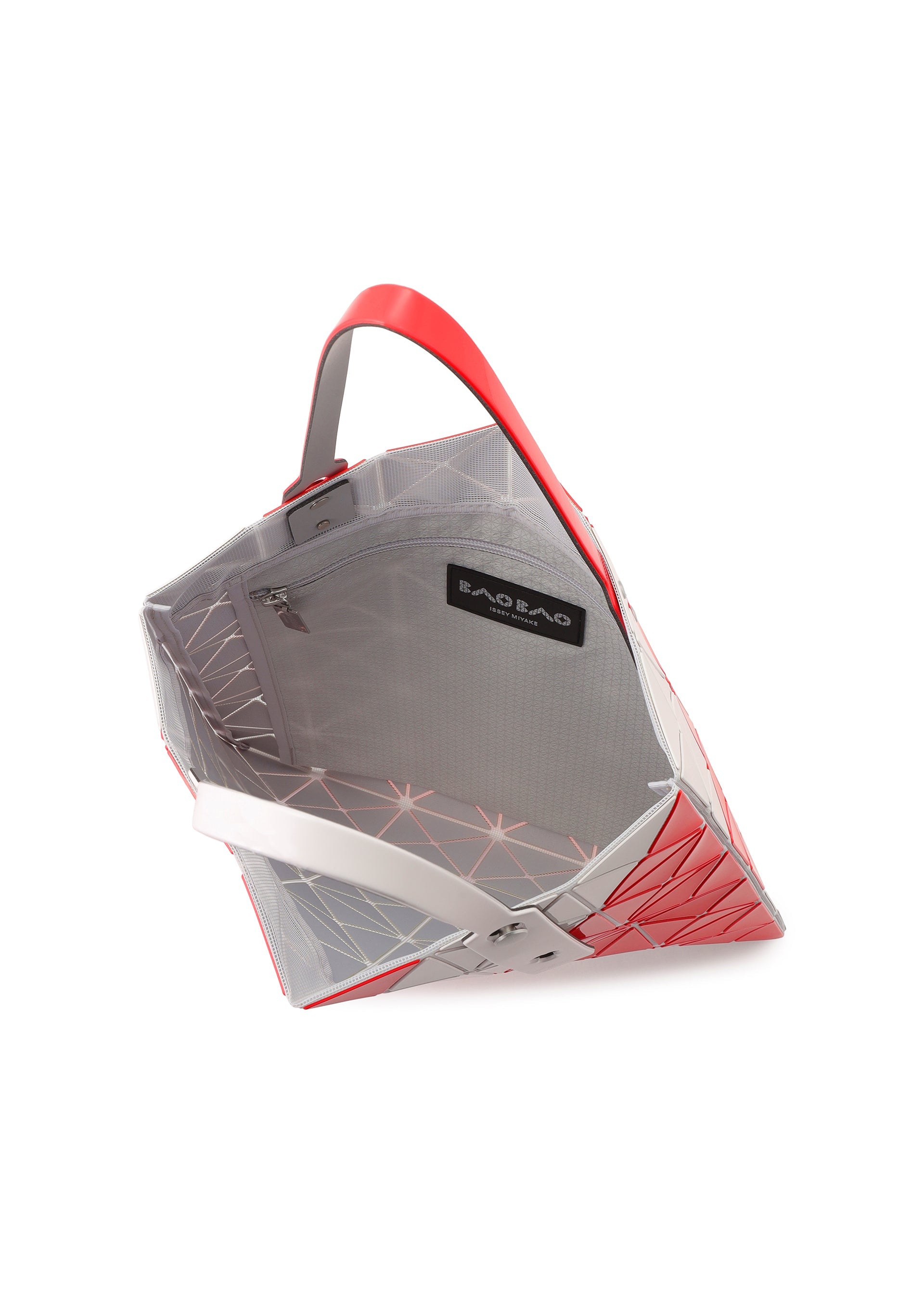 Zoomed view The SIGN tote by BAO BAO ISSEY MIYAKE features red and gray triangular panels, a red handle, and a visible interior zip pocket with a black “BAO BAO” label. Spacious enough for A4 documents or a 13-inch laptop.