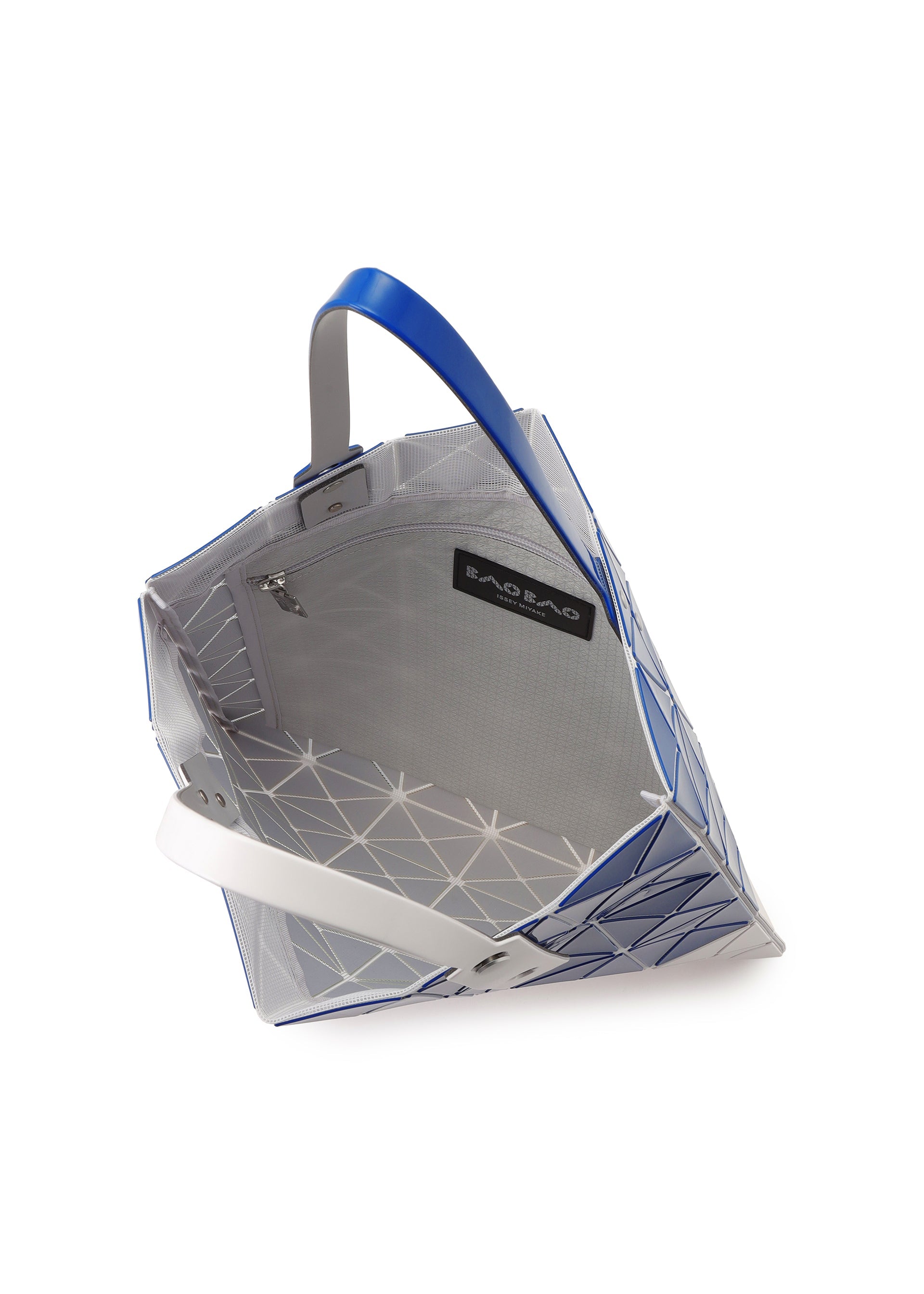 Zoomed view The SIGN tote by BAO BAO ISSEY MIYAKE features a geometric blue and white design, open top, spacious interior for A4 documents or a 13-inch laptop, zippered pocket, black BAO BAO label, and blue and white handles.