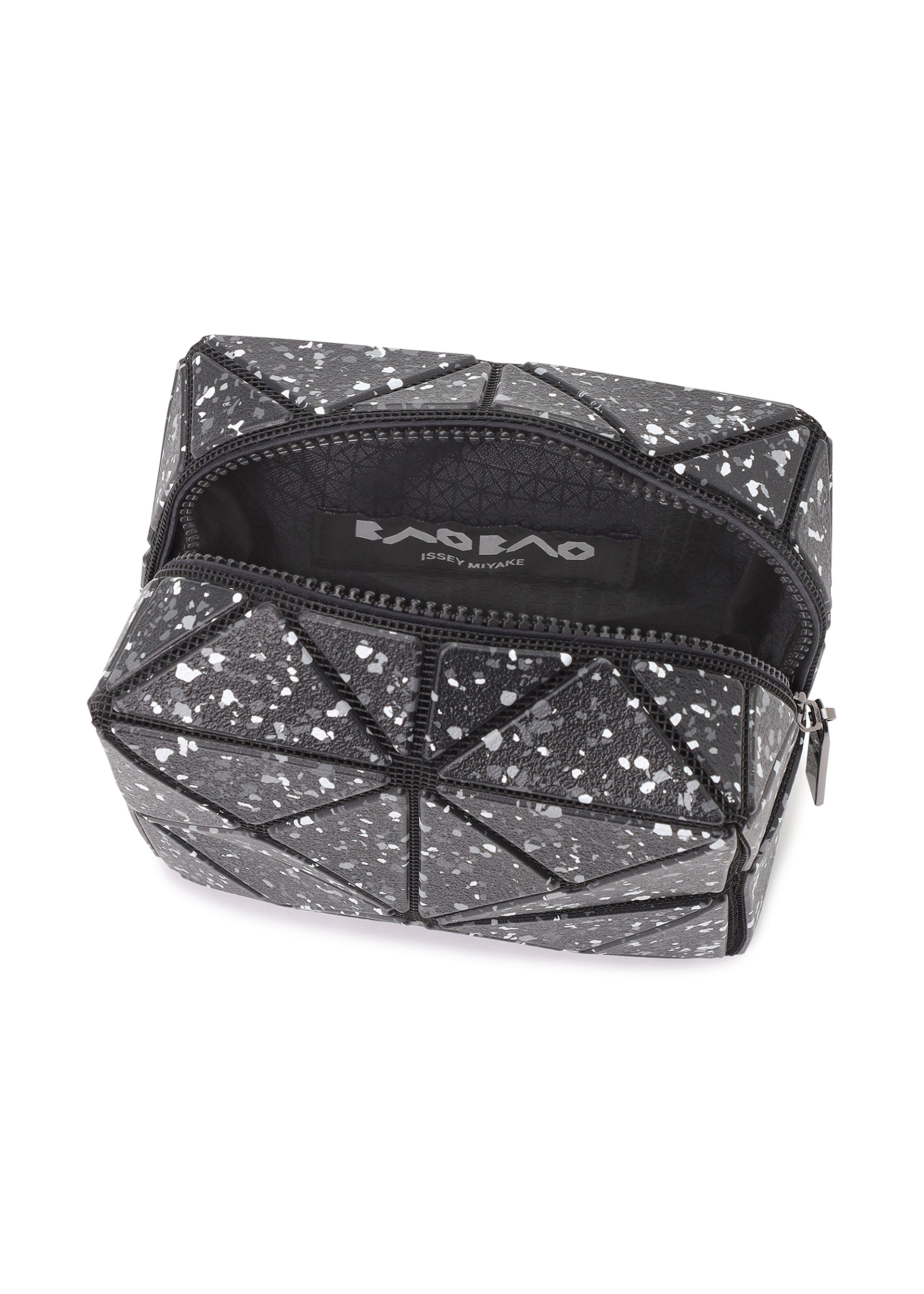 Zoomed view The CITY pouch by BAO BAO ISSEY MIYAKE features a black geometric pattern with white speckles, a sturdy gusset design, and a black interior with a visible brand label.