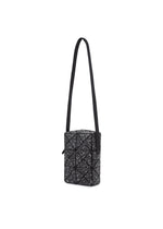 The CITY bag by BAO BAO ISSEY MIYAKE is a small, rectangular shoulder bag in black with a matte, leather-like finish. It features a geometric triangular pattern with white speckles, an adjustable strap, and zippered closure.