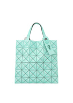 The MINIATURE tote by BAO BAO ISSEY MIYAKE is mint green with geometric triangular patterns, a leather-like finish, two handles with oversized metal hardware, and a matching tag on one handle.