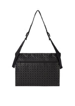The FROGGY shoulder bag by BAO BAO ISSEY MIYAKE is a black rectangular bag featuring a textured geometric triangle pattern, a zippered front pocket, adjustable straps, and spacious storage capacity, shown against a white background.