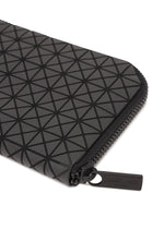A close-up of the BOUND black zippered pouch by BAO BAO ISSEY MIYAKE, showcasing a geometric triangle pattern, card slots, and a black zipper pull tab embossed with the brand name.