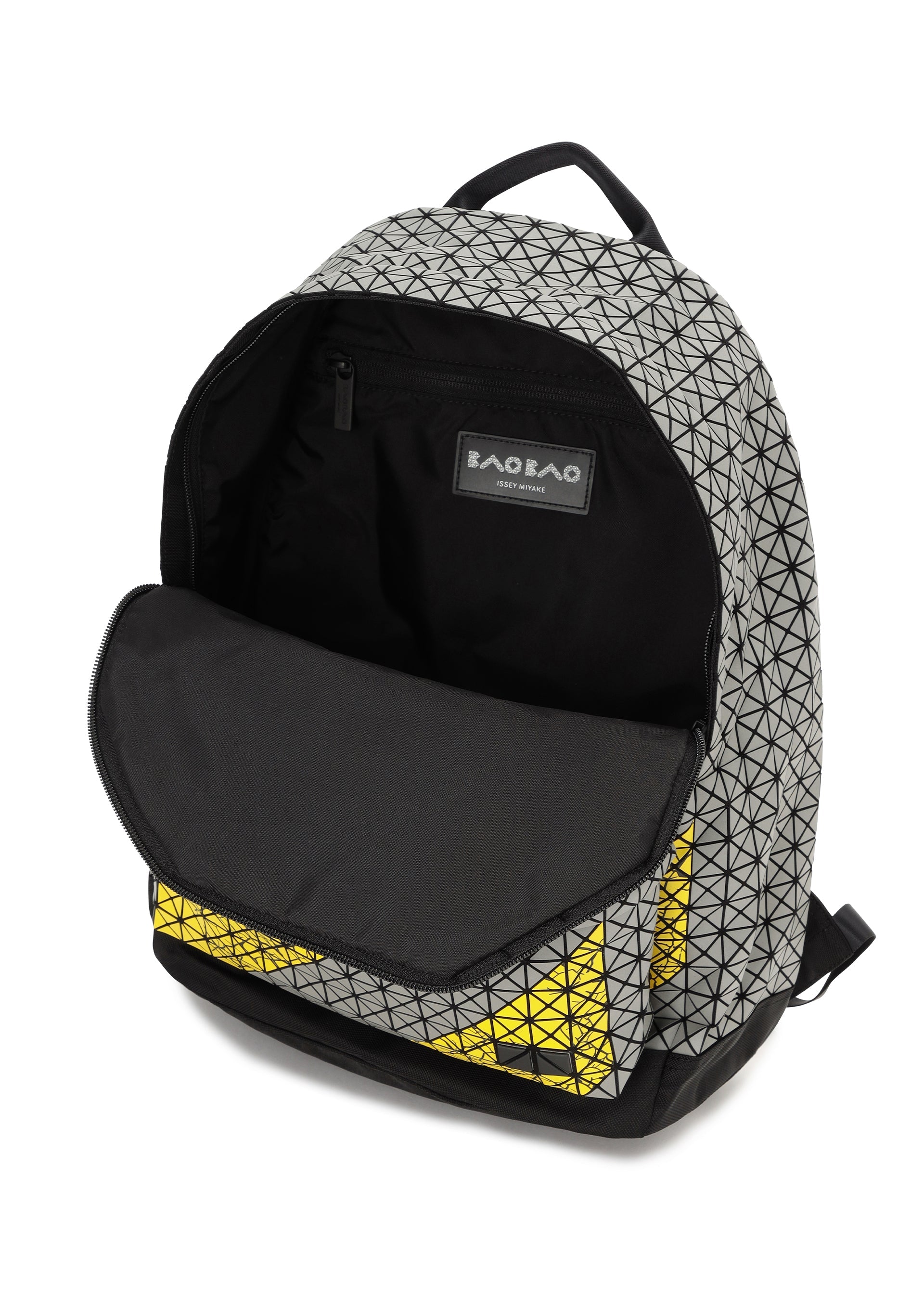 Zoomed view The DAYPACK AUTOBAHN by BAO BAO ISSEY MIYAKE, a unisex backpack with black, grey, and yellow triangular geometric designs, is shown open to reveal a spacious main compartment and an interior zip pocket.