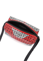 The SADDLE BAG AUTOBAHN by BAO BAO ISSEY MIYAKE features a red and white geometric pattern, boxy shape, black strap, open zipper with unlined dense fabric interior, and an inner black label.