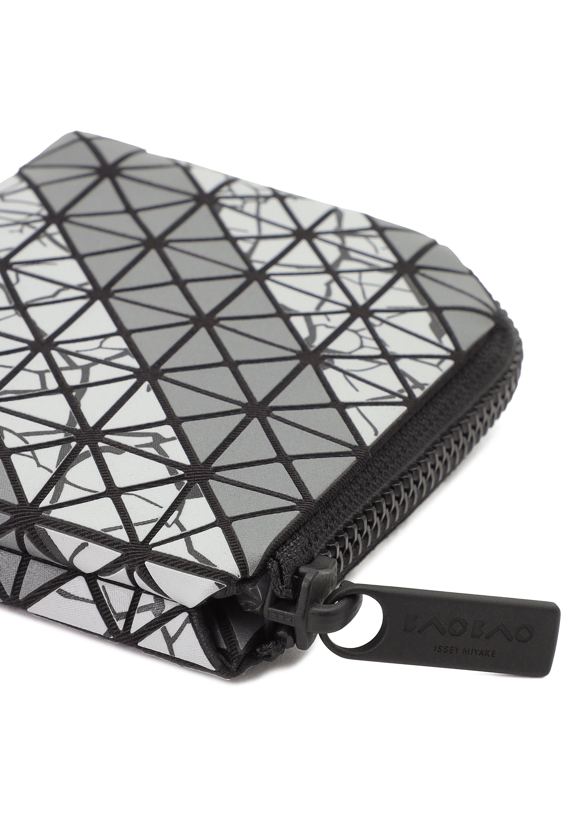 Zoomed view A close-up of the CLAM WALLET AUTOBAHN by BAO BAO ISSEY MIYAKE, featuring a geometric triangle pattern in black, white, and gray with an L-shaped zipper pull. The wallet includes a coin compartment for extra functionality.