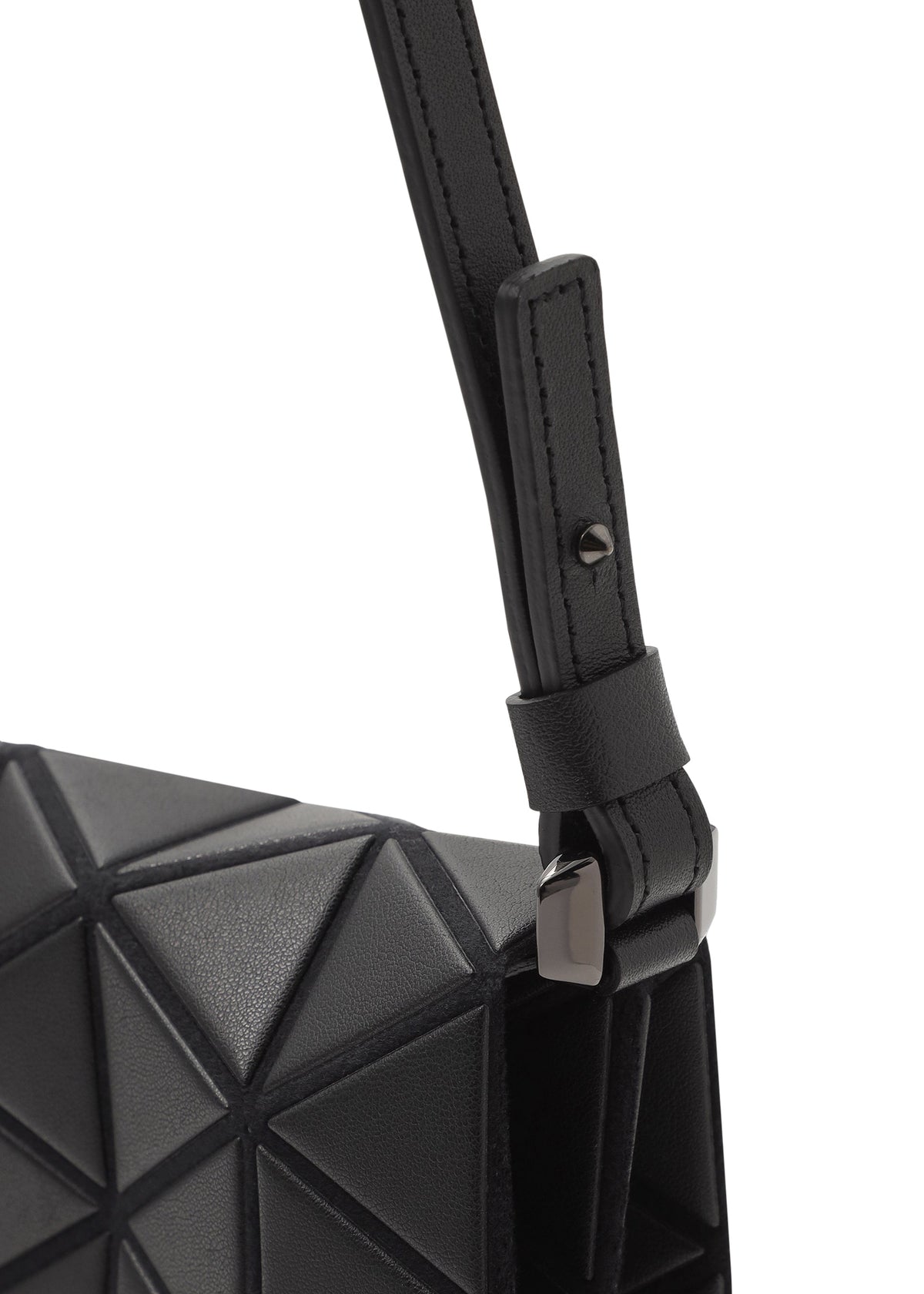 Close-up of the TONNEAU MATTE shoulder bag by BAO BAO ISSEY MIYAKE, showcasing its black geometric triangular-patterned surface, textured strap, and metal buckle detail. view 4 of 6