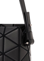 Close-up of the TONNEAU MATTE handbag by BAO BAO ISSEY MIYAKE, showcasing its black geometric-patterned, leather-like surface and angular design, with a strap featuring a silver stud detail that highlights the bag’s unique textures.