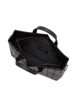 Open black TONNEAU MATTE geometric tote bag by BAO BAO ISSEY MIYAKE, viewed from above, designed to fit A4 size handbag essentials and revealing its spacious interior with fabric lining, zippered pocket, and an inner BAO BAO label. Two black handles are visible on either side of the bag.