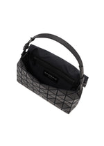 The FOSSETTE handbag by BAO BAO ISSEY MIYAKE is a black geometric-patterned bag with a short handle, an open top secured by a magnetic closure, and features a zippered inner pocket and fabric lining.