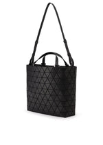The CRYSTAL MATTE by BAO BAO ISSEY MIYAKE is a black handbag with a geometric triangle pattern, two short handles, and leather straps. It's spacious enough to fit A4 documents easily.