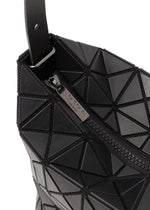 Close-up of the VALLEY handbag by BAO BAO ISSEY MIYAKE, featuring a black geometric pattern, gusseted design, textured triangles, and a zipper pull with engraved branding.