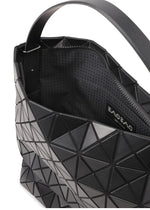 A black geometric self-standing handbag with triangular patterns, partially open to reveal a patterned interior and a visible brand label that reads BAO BAO ISSEY MIYAKE VALLEY.