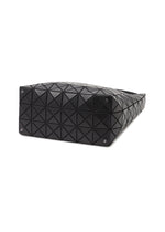 The VALLEY by BAO BAO ISSEY MIYAKE is a black gusseted handbag with a geometric triangular pattern, shown from below. Four small metal studs accent each corner of the base, set against a white background.