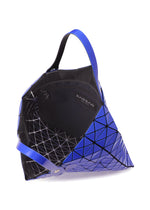 A geometric PRISM GLOSS tote bag by BAO BAO ISSEY MIYAKE in blue and black enamel-like triangular panels, featuring an open top, a single handle, and an interior mesh pocket labeled “BAOBAB.”.