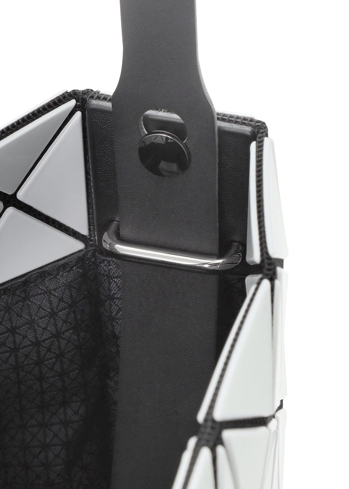 Close-up of a geometric patterned white shoulder bag from the PRISM GLOSS collection by BAO BAO ISSEY MIYAKE, featuring black trim and a black strap attached inside with a metal bar and button detail. The bag’s surface has an enamel-like finish for a sleek, modern look. view 7 of 10