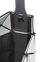 Close-up of a geometric patterned white shoulder bag from the PRISM GLOSS collection by BAO BAO ISSEY MIYAKE, featuring black trim and a black strap attached inside with a metal bar and button detail. The bag’s surface has an enamel-like finish for a sleek, modern look.