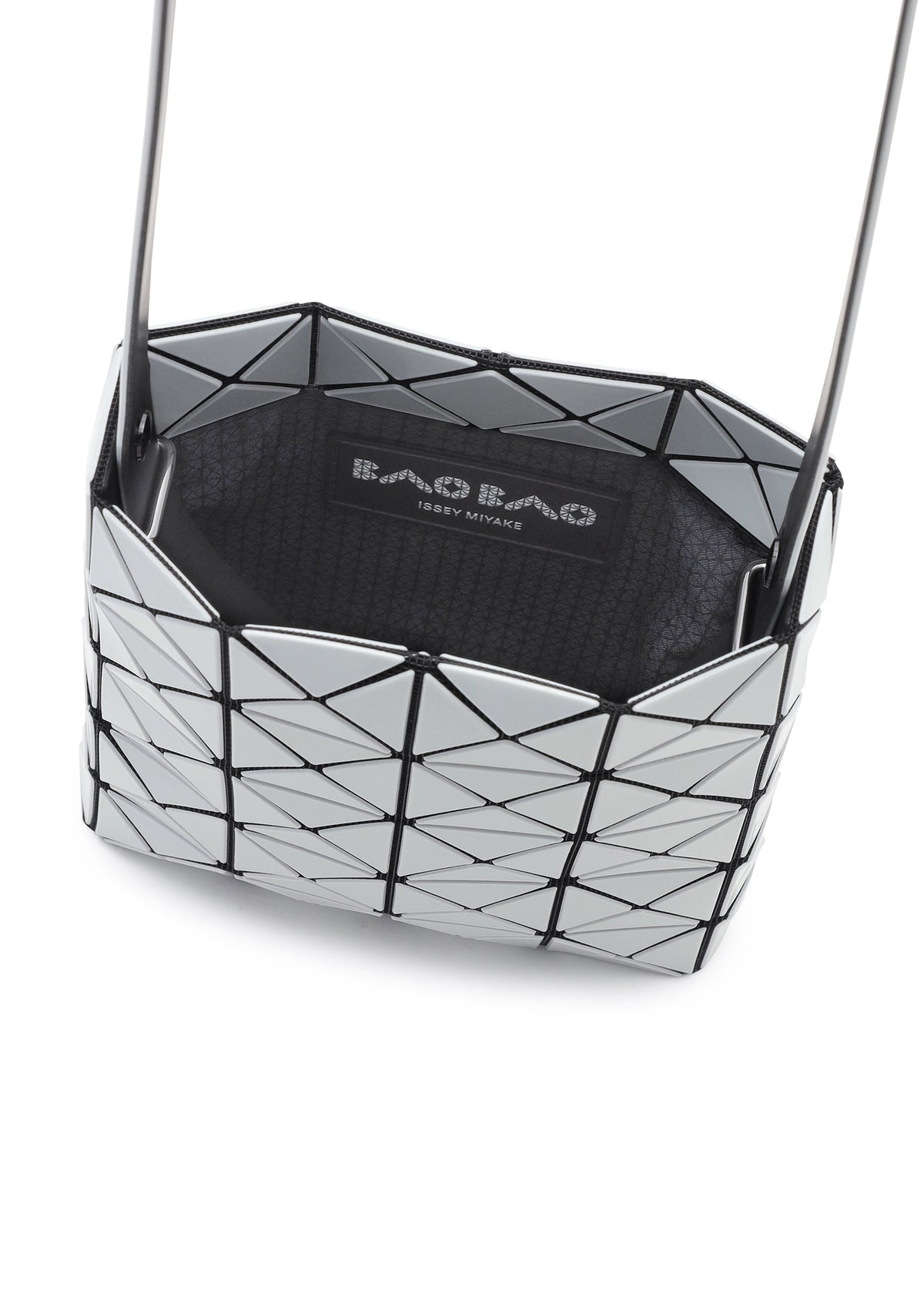 A close-up of a silver geometric-patterned BAO BAO ISSEY MIYAKE PRISM GLOSS shoulder bag, crafted from an enamel-like material with black accents and a visible brand label inside. view 8 of 10