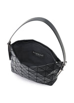 The MUSETTE handbag by BAO BAO ISSEY MIYAKE features a black geometric pattern, crafted from a leather-like material. It has an open top that reveals a spacious interior and includes a single sturdy handle. The inner label displays the brand name, BAO BAO ISSEY MIYAKE.