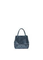 The CARAT handbag by BAO BAO ISSEY MIYAKE is a small, dark blue accessory with a geometric pattern, crafted from metallic material. It features two handles, a matching tag, and an inner pocket, and is displayed on a white background. - OBSIDIAN BLACK （no.19）
