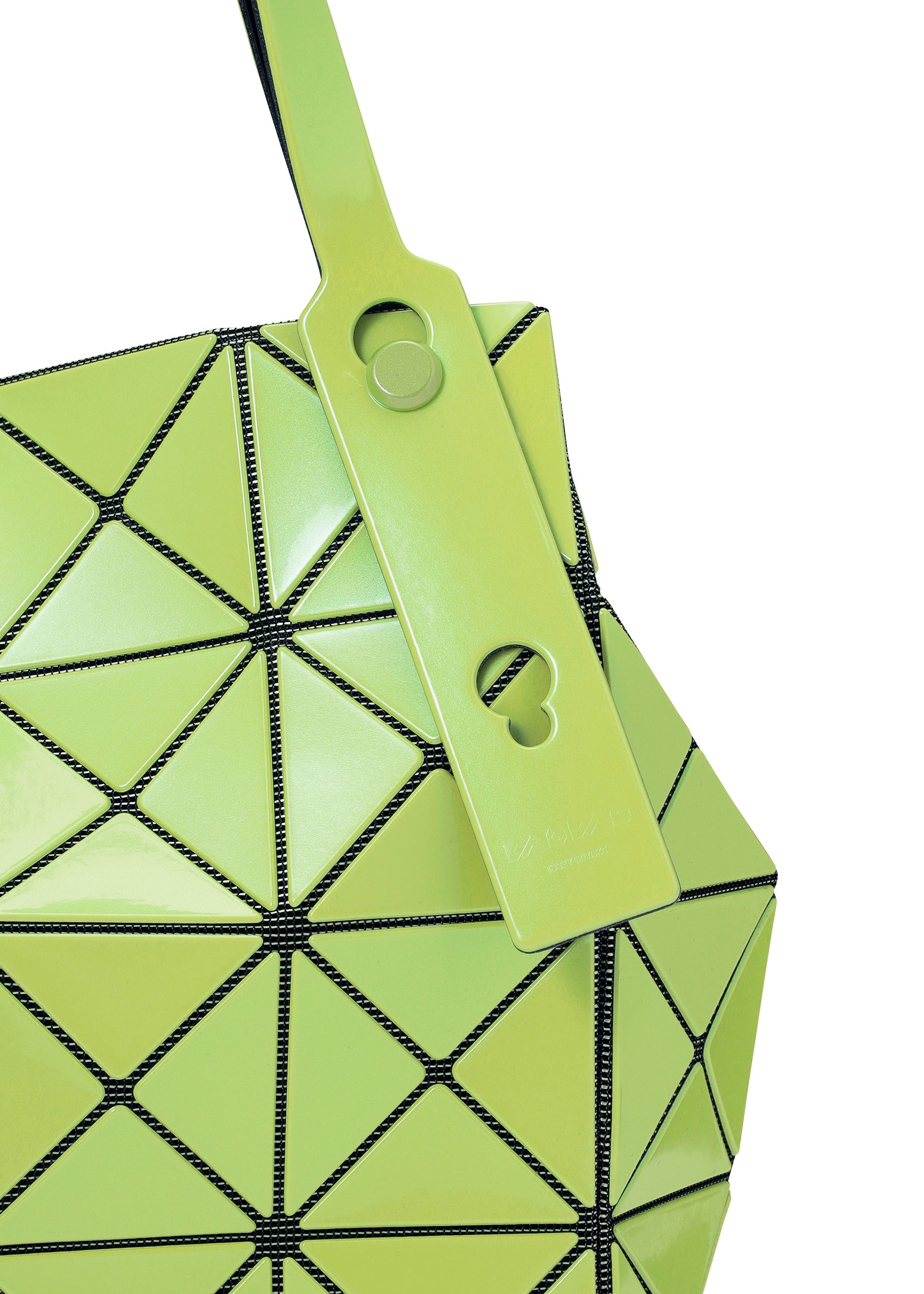 Zoomed view Close-up of the BAO BAO ISSEY MIYAKE CARAT handbag, featuring geometric green metallic triangular panels with black seams. A matching green tag adorned with circular cutouts hangs from one handle, while a discreet zippered pocket enhances both style and functionality.