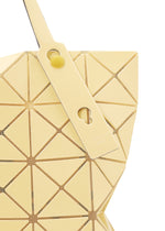 Close-up of the BAO BAO ISSEY MIYAKE LUCENT ONE-TONE tote, showcasing pale yellow glossy enamel geometric panels, perforated edges, a matching strap, and a round yellow button accent.