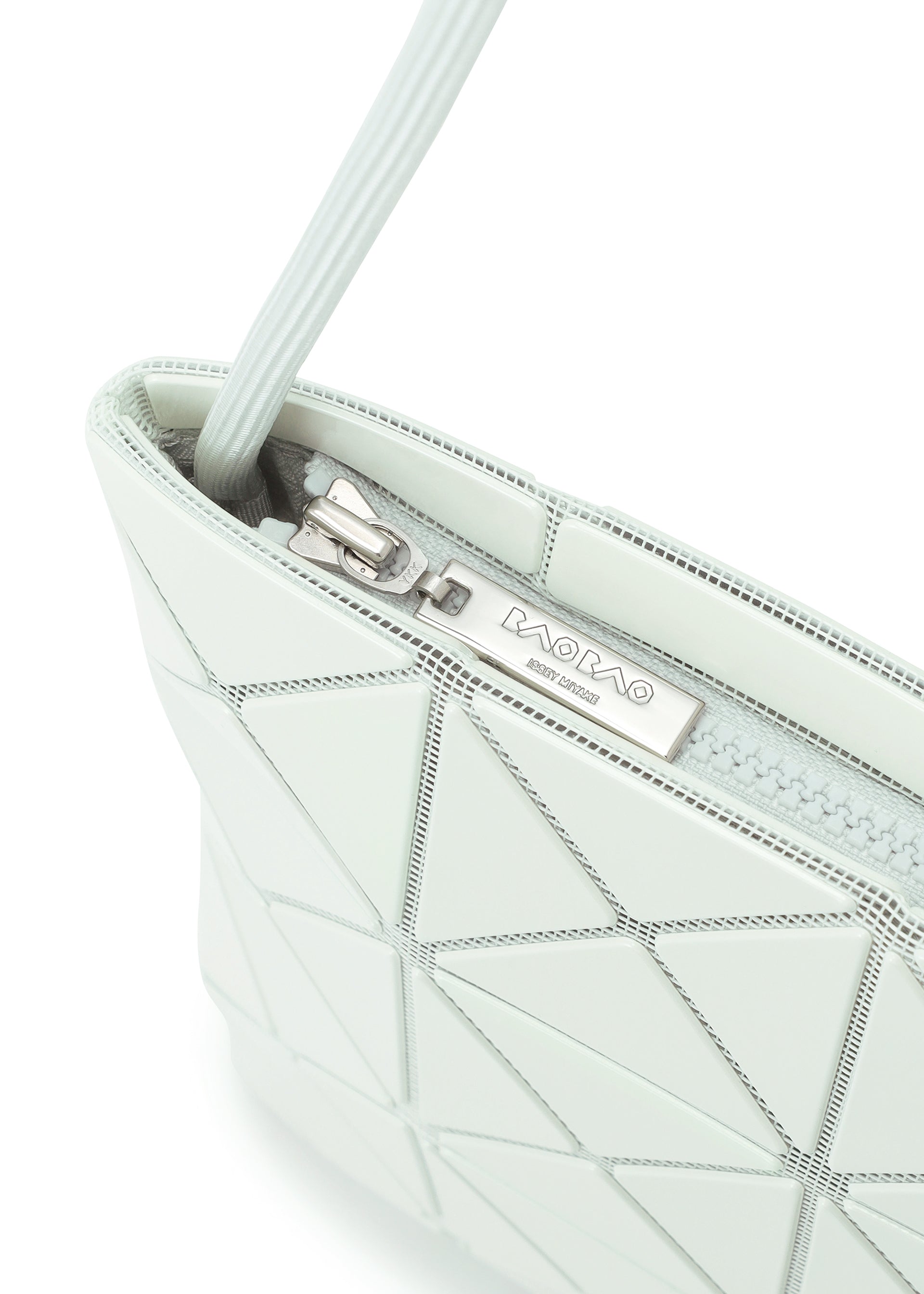 Zoomed view Close-up of a light grey geometric-patterned LUCENT ONE-TONE tote bag by BAO BAO ISSEY MIYAKE, featuring a silver zipper and a metal brand label.