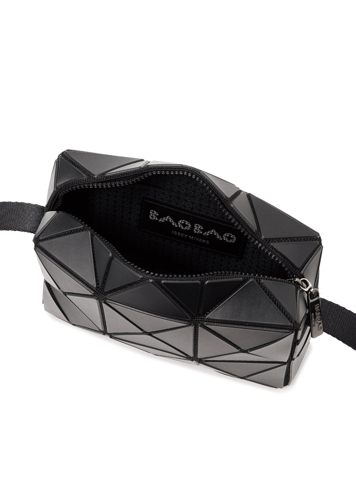 A black CUBOID shoulder bag by BAO BAO ISSEY MIYAKE featuring a geometric, angular design with an adjustable strap. The zipper is partially open, revealing a black fabric interior and a label that reads “BAO BAO ISSEY MIYAKE.”. view 6 of 8