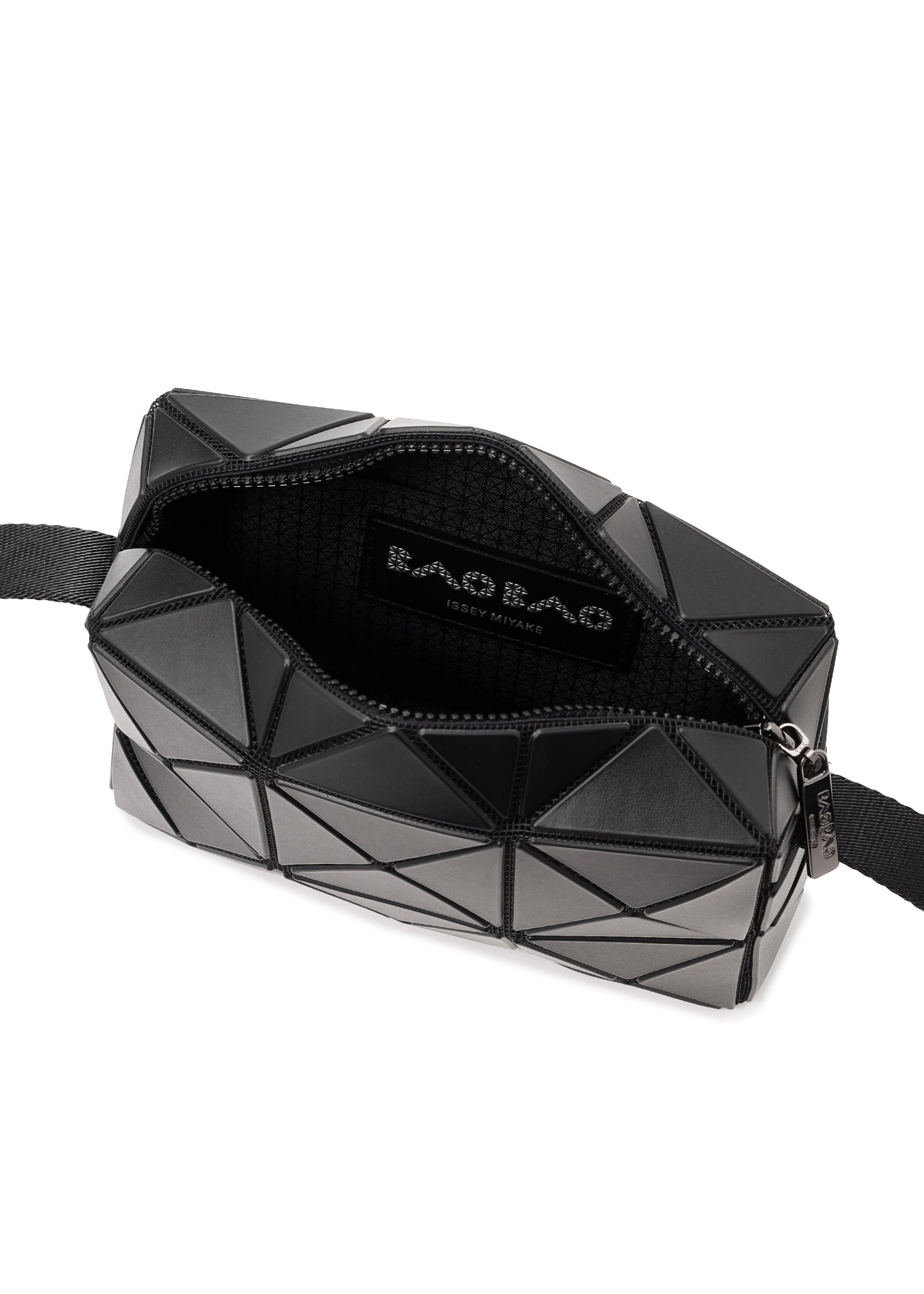 Zoomed view A black CUBOID shoulder bag by BAO BAO ISSEY MIYAKE featuring a geometric, angular design with an adjustable strap. The zipper is partially open, revealing a black fabric interior and a label that reads “BAO BAO ISSEY MIYAKE.”.