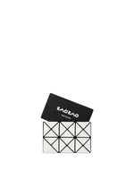 A geometric black-and-white TWINKLE clutch bag with triangular patterns and minimalist design sits open, displaying the BAO BAO ISSEY MIYAKE logo on its inner flap against a plain white background.
