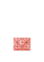 A small, rectangular pink CARD WALLET by BAO BAO ISSEY MIYAKE with a geometric quilted pattern and studded edges, ideal for a cash-less lifestyle or as a chic card case, shown centered on a plain white background. - SUNSET CORAL （no.31）