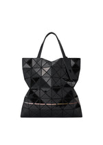 The WARP by BAO BAO ISSEY MIYAKE is a black geometric tote bag featuring a unique triangular mosaic print, dual handles, and a shiny enamel finish for a reflective, modern sculptural look.