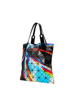 The WARP tote by BAO BAO ISSEY MIYAKE features flexible black geometric panels with a vibrant, reflective blue, red, yellow, and white print. Made from enamel material, it has two black handles and a sleek, futuristic design.