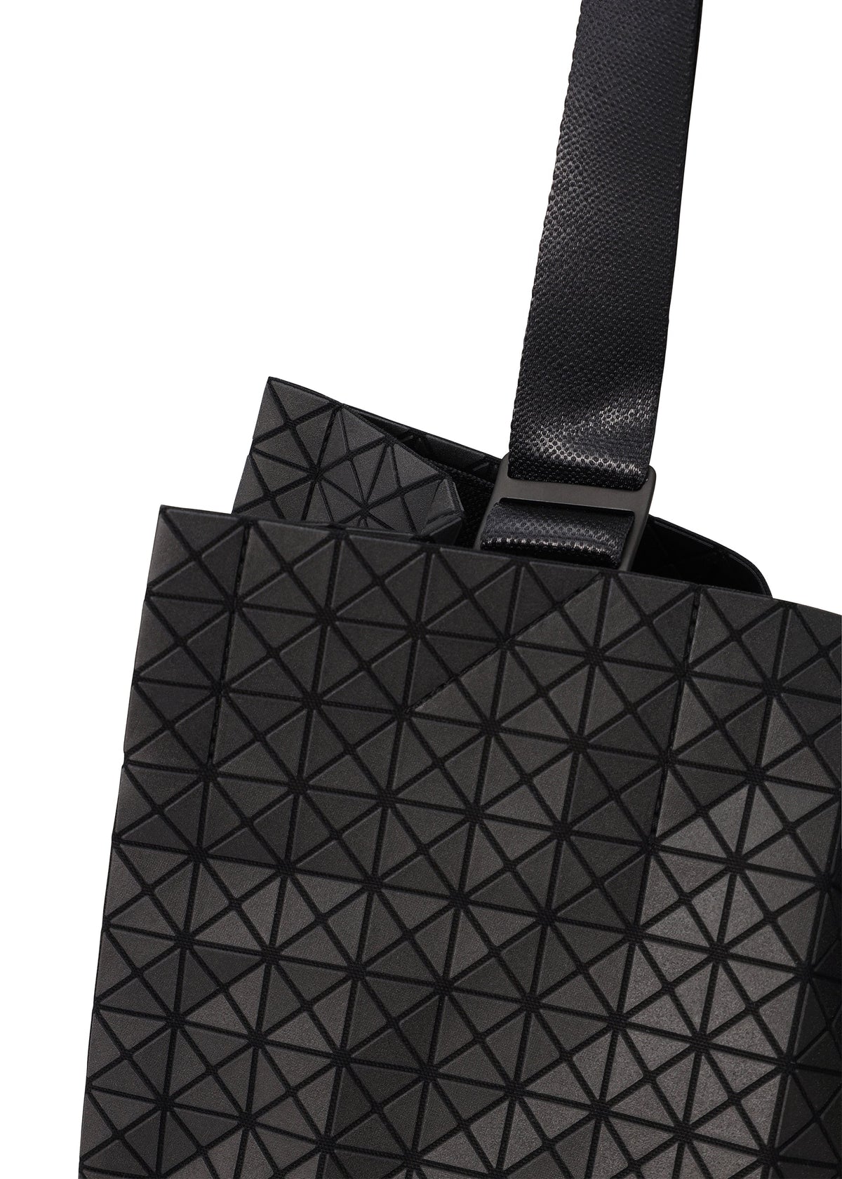 Close-up of a CART tote bag by BAO BAO ISSEY MIYAKE, featuring a black geometric-patterned design with adjustable handles and a wide textured strap. Raised triangles form a striking grid, making it ideal as an A4 laptop bag. view 3 of 6
