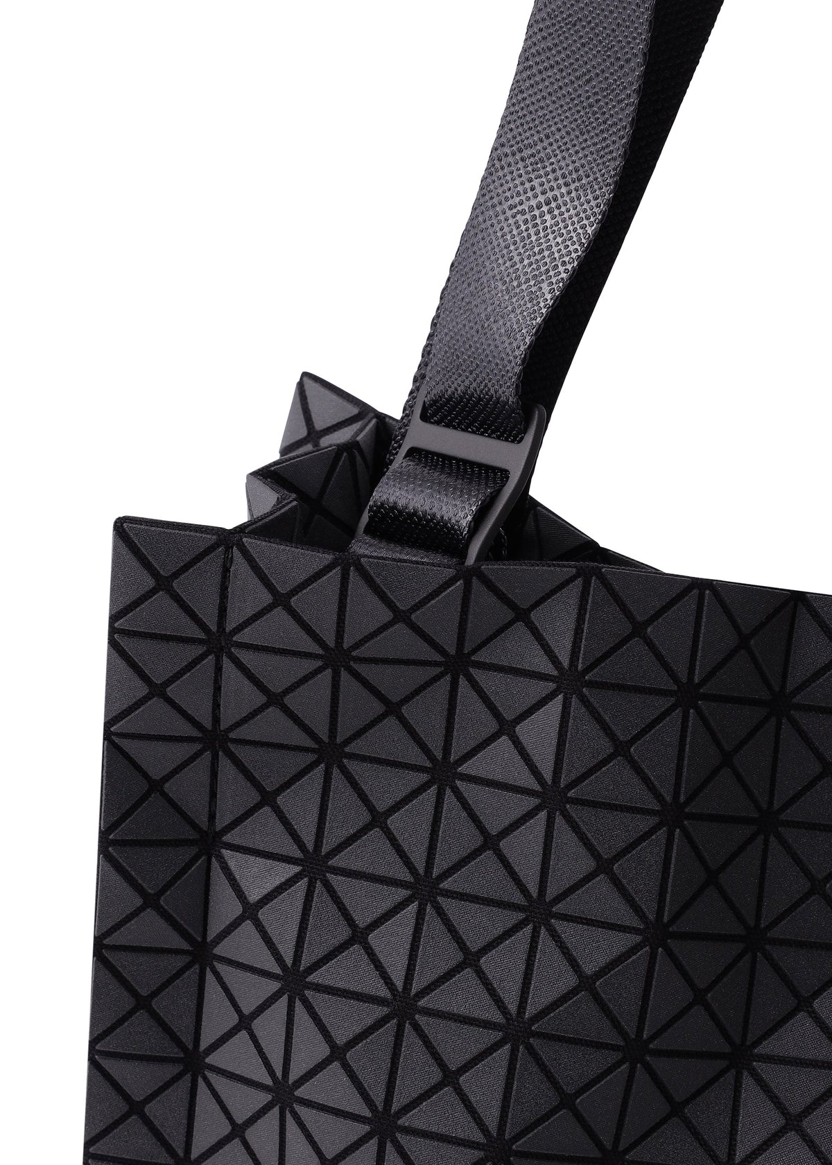 Zoomed view Close-up of the CART MINI by BAO BAO ISSEY MIYAKE, a black mini tote with a strap and buckle, featuring a geometric pattern of triangular shapes for a modern textured look against a white background.