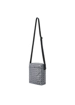 The VOYAGER REFLECTOR by BAO BAO ISSEY MIYAKE is a rectangular crossbody bag with a geometric triangular pattern, a long adjustable black strap, and zippered top, styled against a white background.
