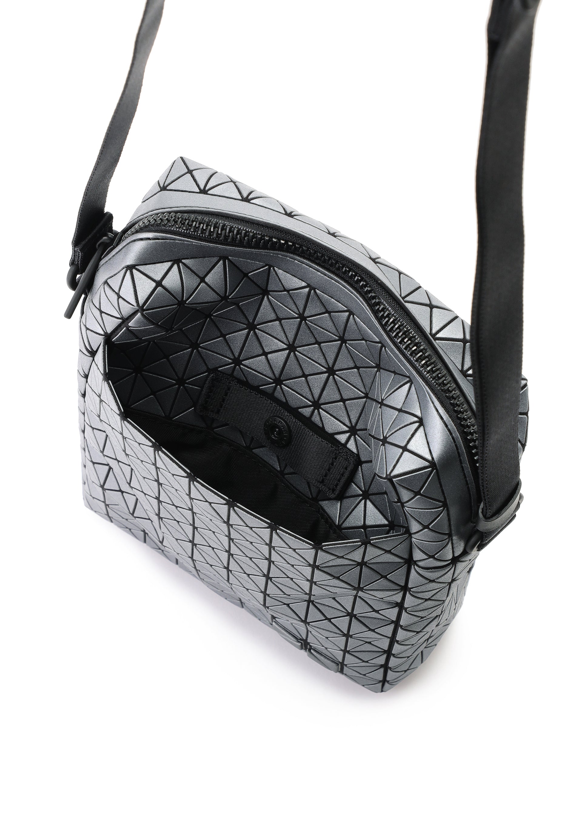 Zoomed view The VOYAGER REFLECTOR tote by BAO BAO ISSEY MIYAKE features a silver geometric metallic design, black strap, open zipper, and small front pocket, showcased against a white background.