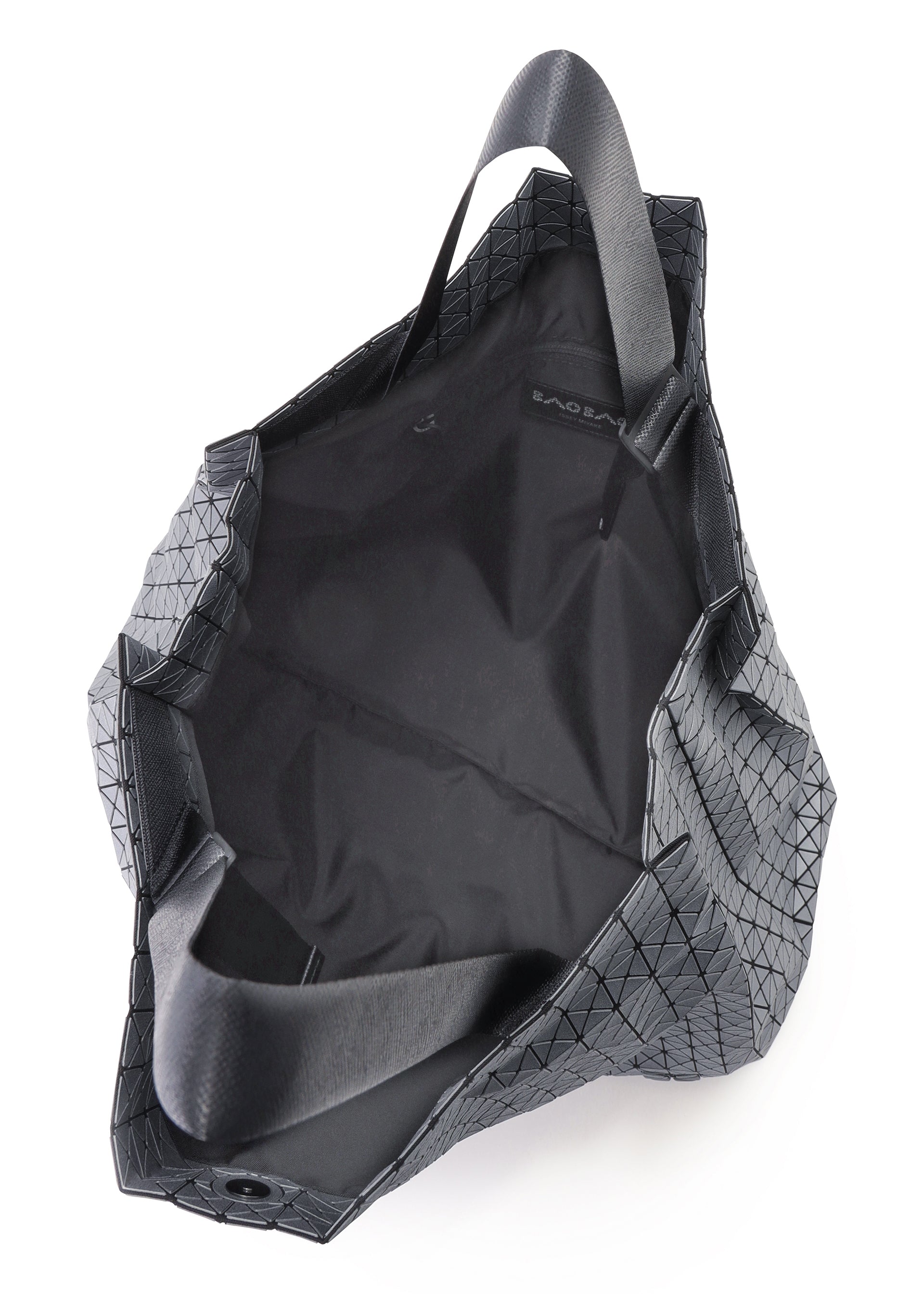 Zoomed view The CART REFLECTOR by BAO BAO ISSEY MIYAKE is a black tote bag with a geometric pattern and adjustable handles, shown from above to display its spacious, unlined interior and a small inner label.