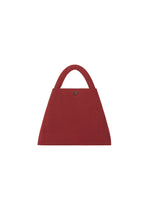 The KURURI by GOOD GOODS ISSEY MIYAKE is a red, triangular fabric bag with a curved, adjustable handle and single button closure, shown against a plain white background.