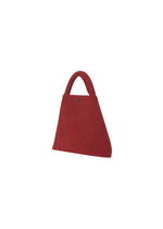The KURURI by GOOD GOODS ISSEY MIYAKE is a small red triangular fabric bag featuring a rounded adjustable handle and button detail near the top, shown against a plain white background.