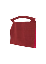 The KURURI by GOOD GOODS ISSEY MIYAKE is a minimalist flat red suede handbag featuring a sturdy handle and snap closure, shown against a white background.