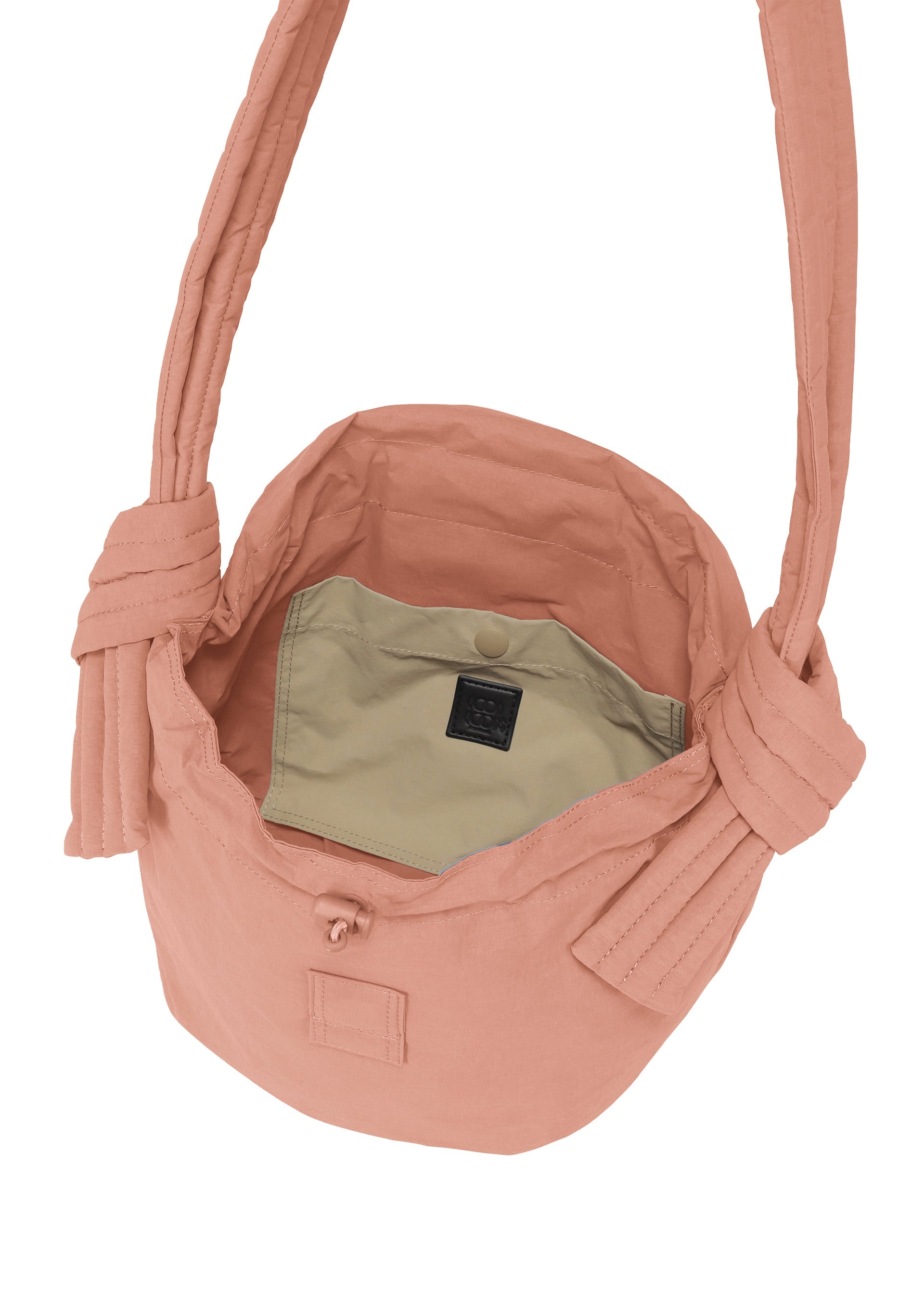 Zoomed view The FUWA FUWA by GOOD GOODS ISSEY MIYAKE is a peach shoulder bag inspired by Japanese noragi, featuring wide knotted straps, an open top, a beige inner pocket with a black label, and a snap button closure.