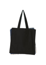 A black IROGAMI SALT DYE tote bag by GOOD GOODS ISSEY MIYAKE, featuring long handles and layered over colorful sections peeking from the sides, displayed against a white background.
