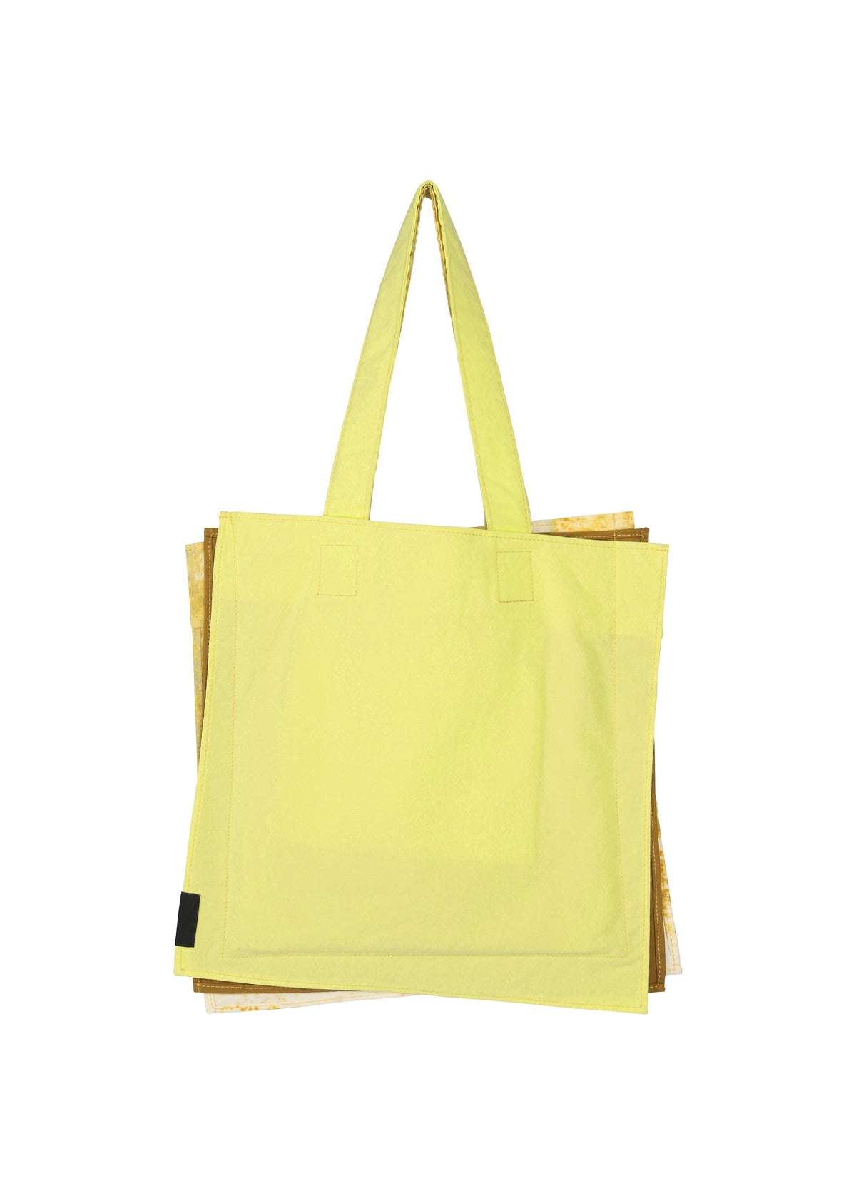 A large yellow IROGAMI SALT DYE tote bag by GOOD GOODS ISSEY MIYAKE, featuring Shio-zome dyeing and two shoulder straps, is shown on a plain white background with part of a brown or gold bag partially visible behind it. view 4 of 10