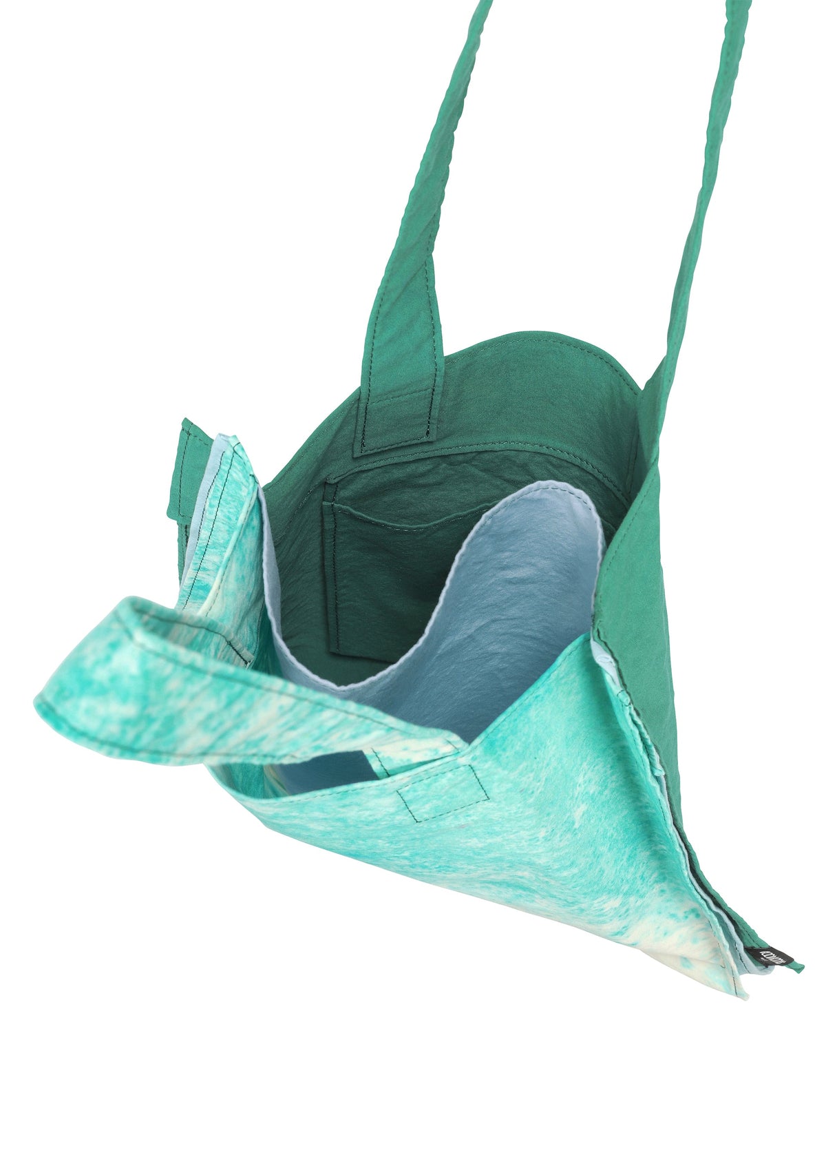 The IROGAMI SALT DYE tote by GOOD GOODS ISSEY MIYAKE features teal and turquoise fabric, an open top, spacious unlined interior, and sturdy straps. Photographed from above at an angle on a white background. view 7 of 10