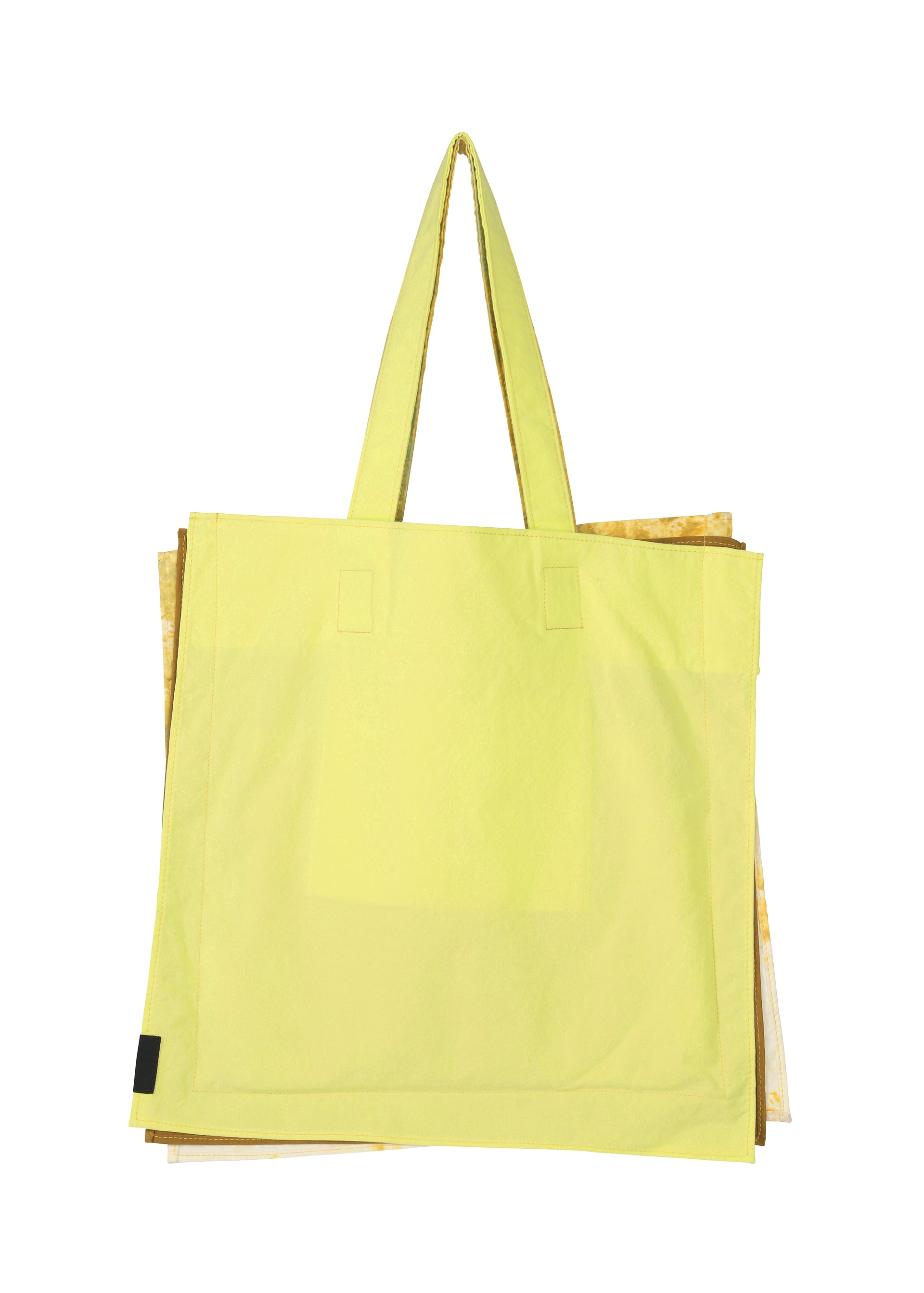Zoomed view A large, light yellow IROGAMI SALT DYE tote bag by GOOD GOODS ISSEY MIYAKE with two handles. Part of a gold or beige object peeks out from behind. Set against a plain white background. Features unique Shio-zome dyeing technique.
